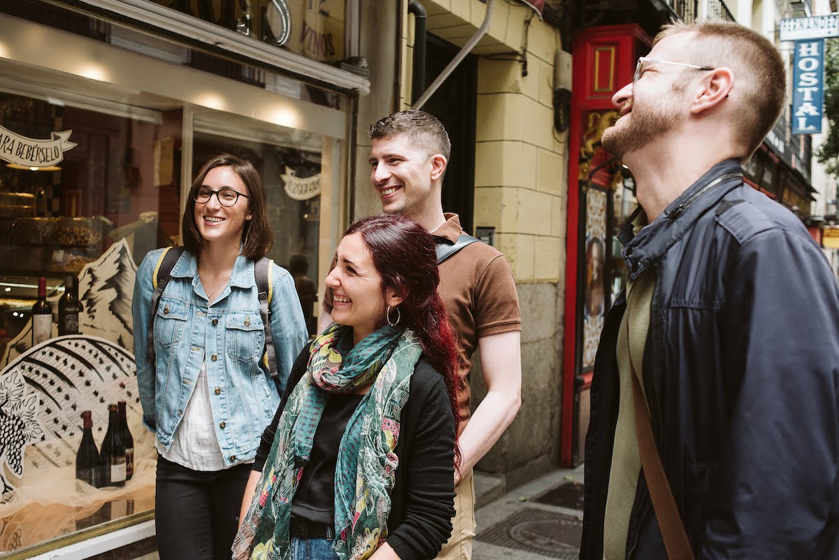 A group of people talking and smiling outside a restaurant