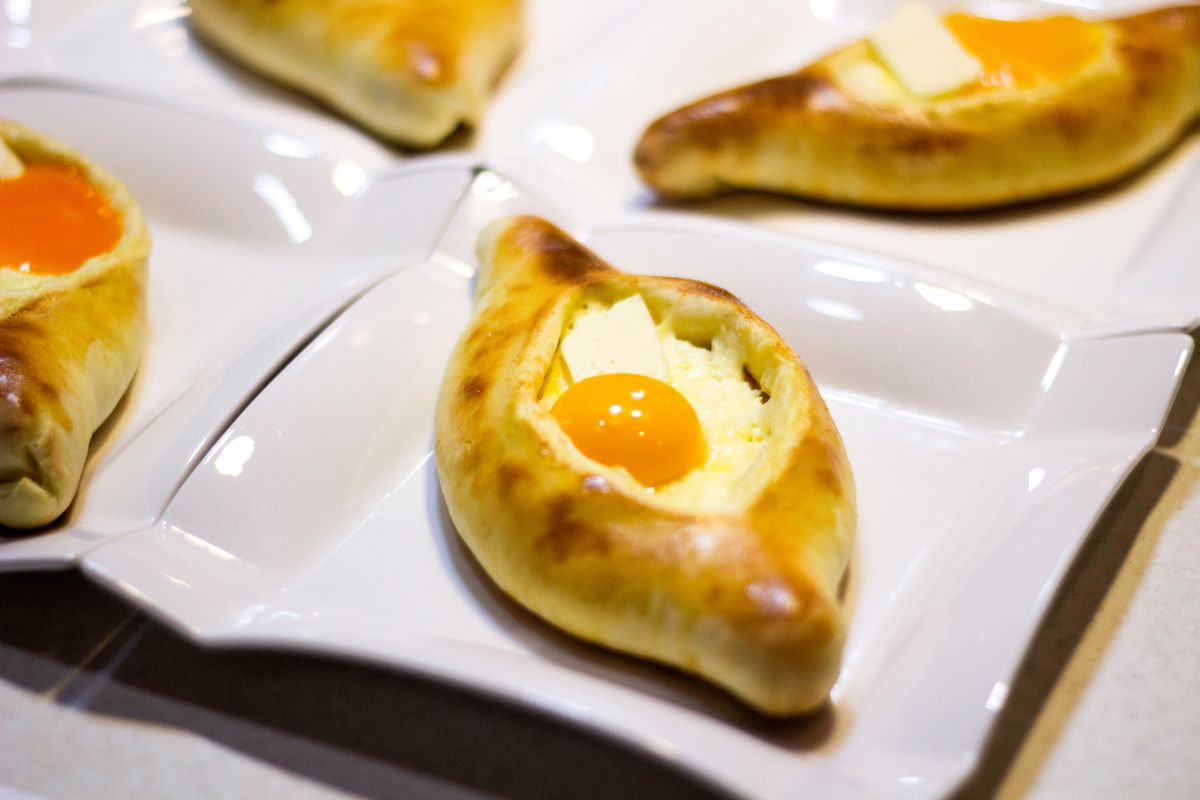 khachapuri baked bread with cheese and eggs - classic georgian food in nyc