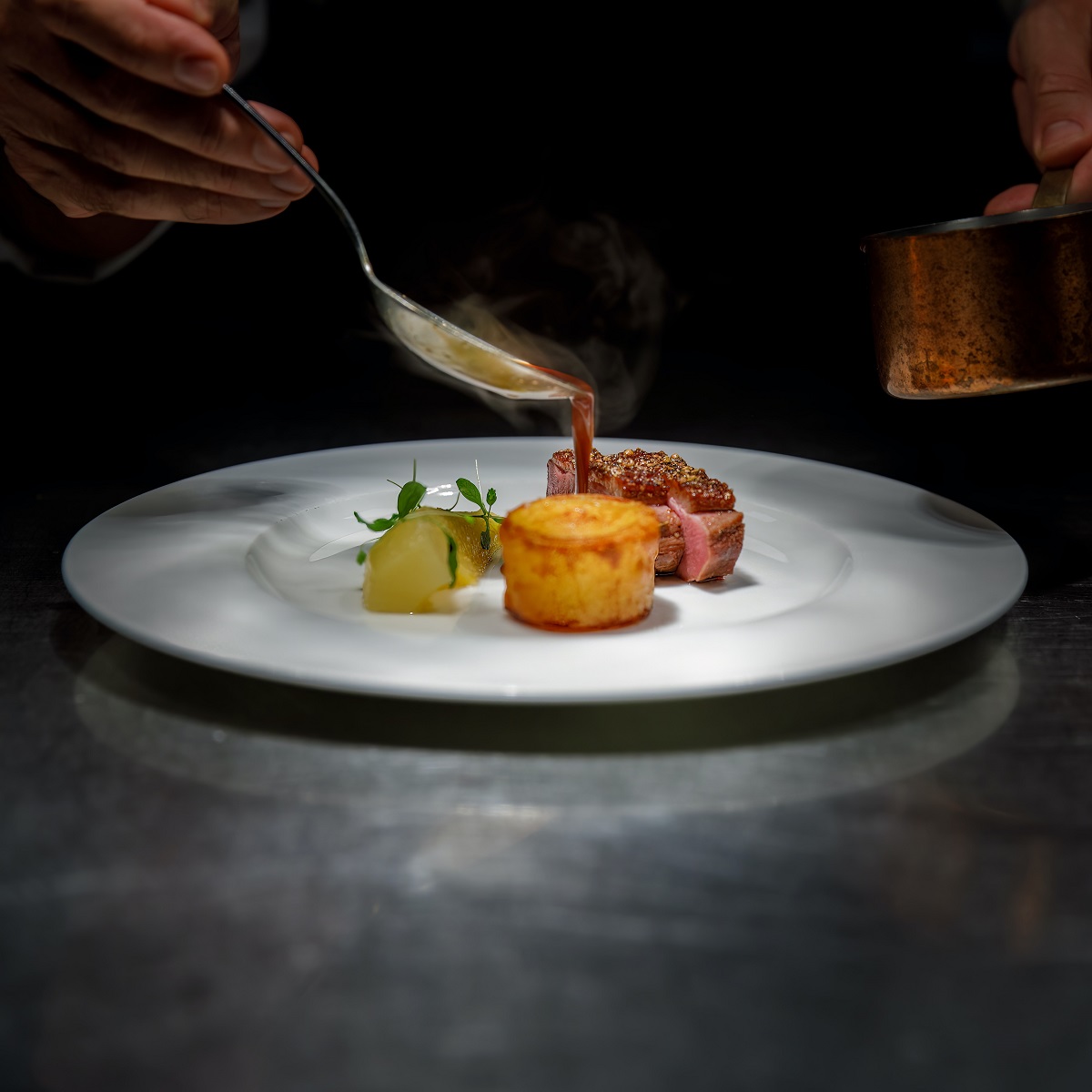 Chef plating a dish at a michelin starred restaurants in italy
