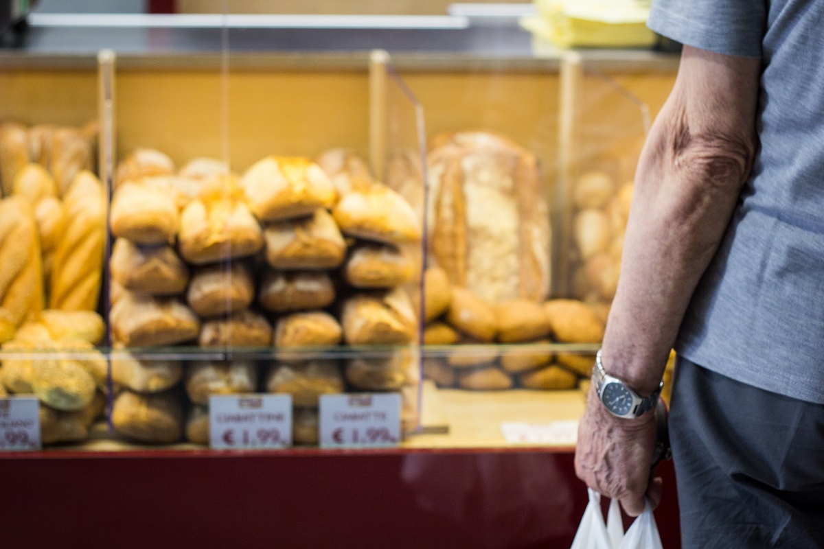 rows of bread and man holding bags