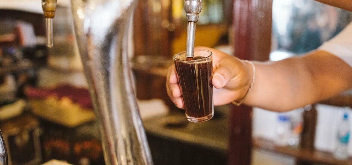 Close up of a bartender pouring vermouth on tap into a small glass