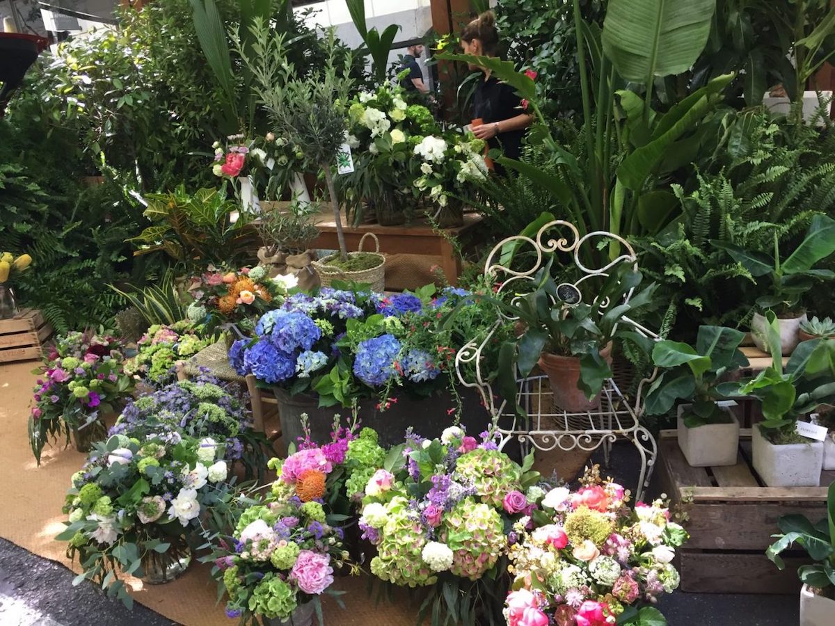 Plants and brightly colored flowers displayed at a floral market
