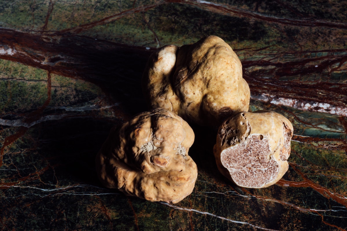 Three white truffles positioned against a dark background