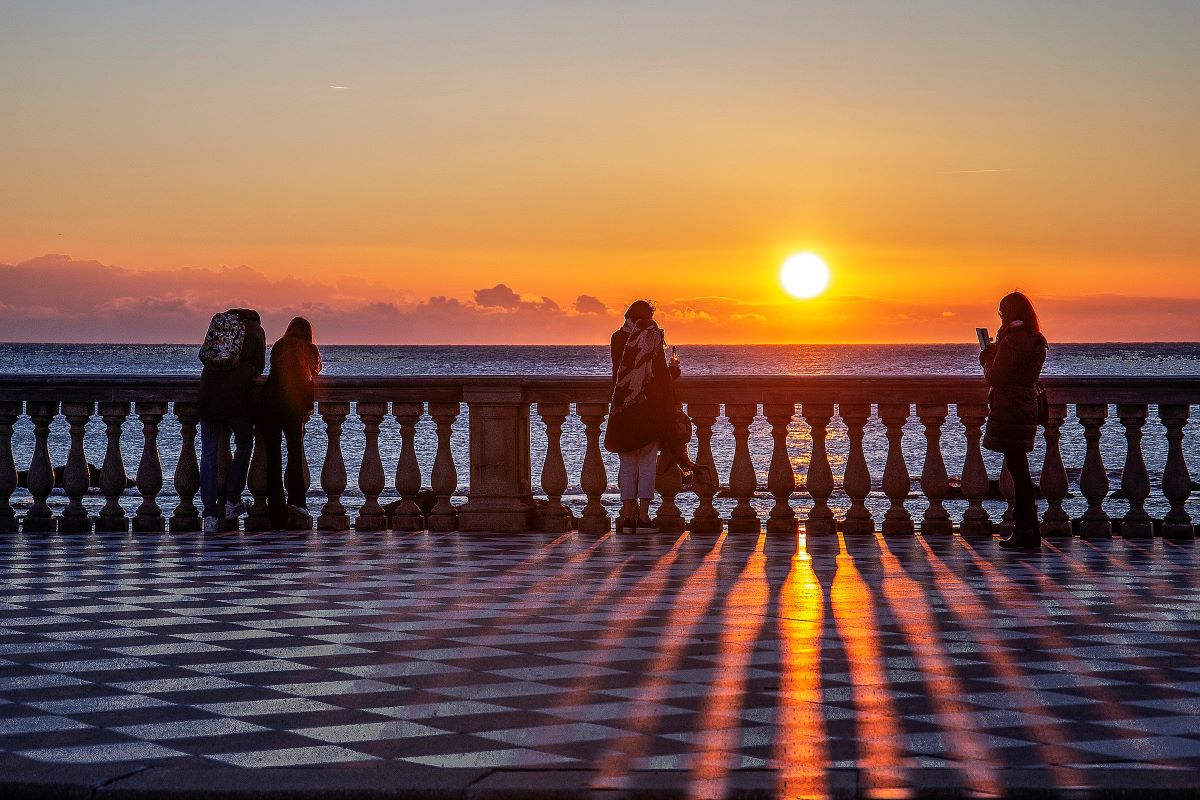 people watching the sunset on a balcony in town in Tuscany