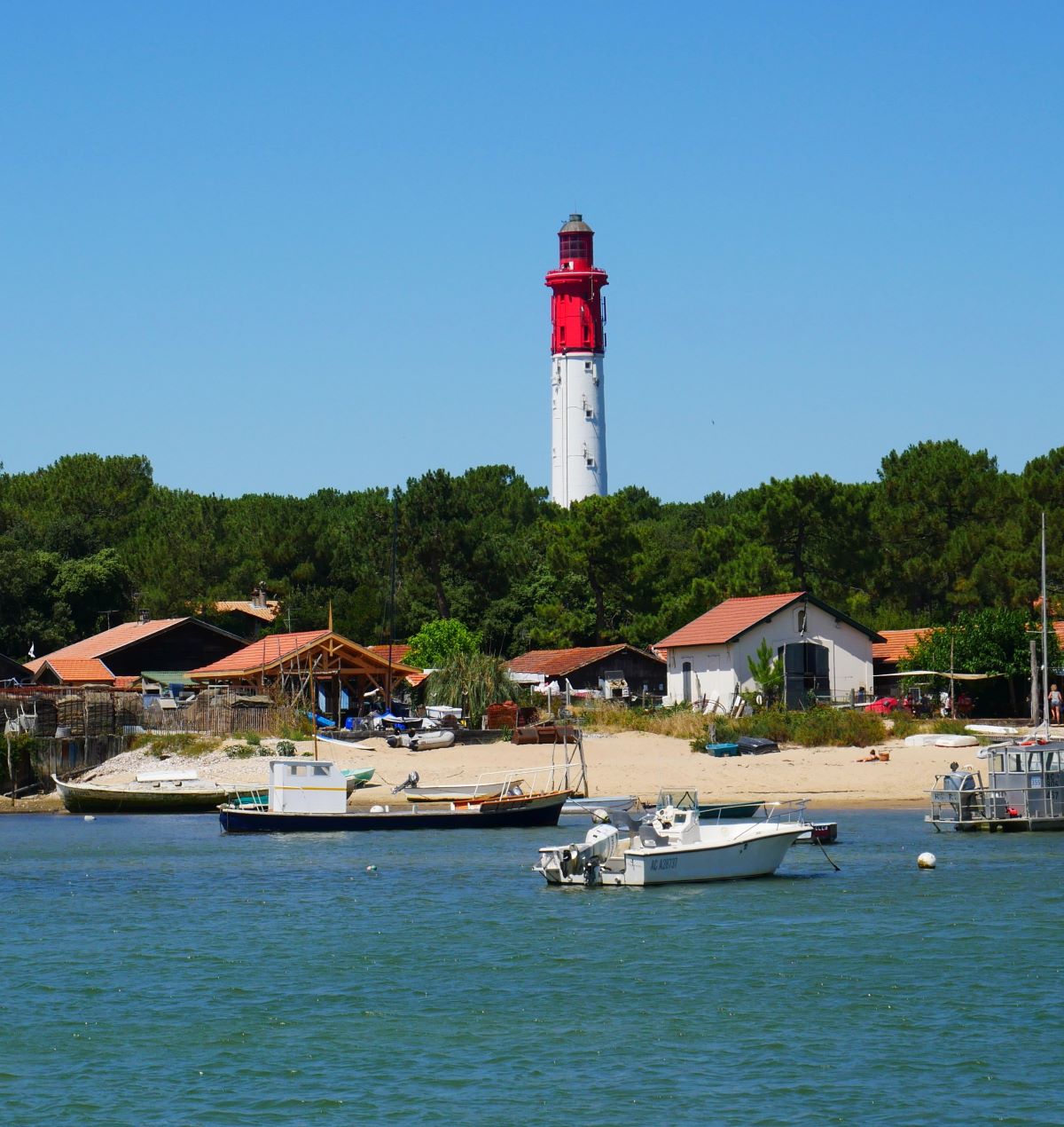 A lighthouse with boats in the foreground
