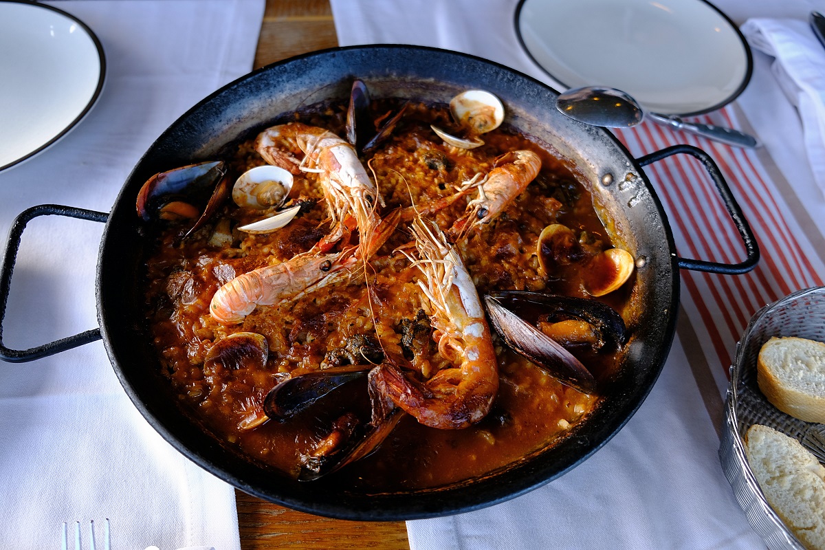 Small paella dish with seafood and shrimp on a table top with white dining cloth